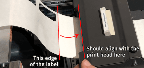 Align label edge to print head using the print head button